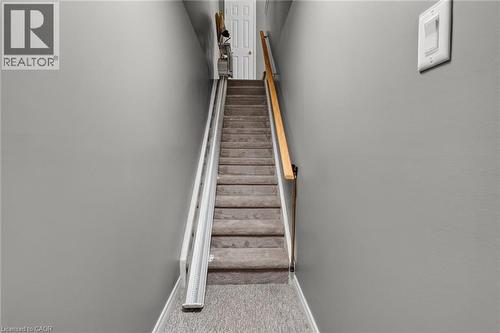 Carpeted staircase with a wooden handrail and a chair lift system to the basement (chair lift is optional) - 159 Thoroughbred Boulevard, Ancaster, ON 