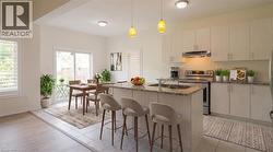 Kitchen featuring stainless steel appliances, light-toned cabinetry, and a center island with an undermount sink - 
