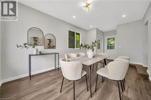 Wood-finish flooring, recessed lighting, contemporary ceiling light fixture, white trim, and a window with outdoor scenery - 284 Cedar Crescent, Cambridge, ON 