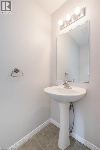 Pedestal sink with chrome faucet, wall-mounted mirror, and three-bulb vanity light - 224 Jessica Crescent Unit# B, Kitchener, ON 