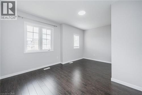 Wood-finish flooring throughout, white trim, and a window with white blinds - 224 Jessica Crescent Unit# B, Kitchener, ON 