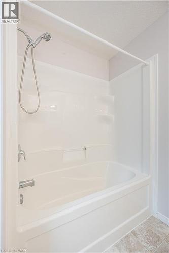 White fiberglass tub-shower combination with a handheld shower head and chrome fixtures - 224 Jessica Crescent Unit# B, Kitchener, ON 