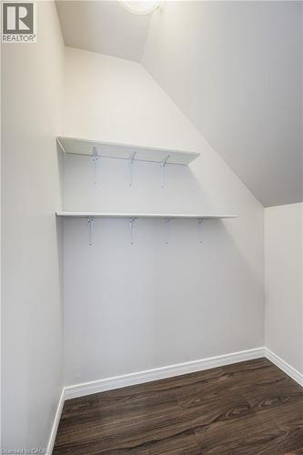 Angled ceiling storage area with two white shelves, wood-finish flooring, and white wall paint - 224 Jessica Crescent Unit# B, Kitchener, ON 