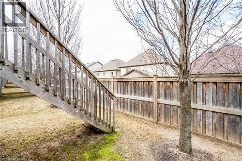 Wood-paneled fencing enclosing the property with a visible outdoor staircase - 224 Jessica Crescent Unit# B, Kitchener, ON 