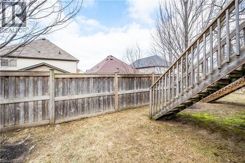 Grassed outdoor area with a wood privacy fence and a wood staircase - 224 Jessica Crescent Unit# B, Kitchener, ON 