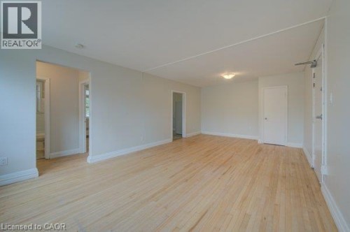 Light wood-finish flooring, white wall paint, and white trim - 141 Chapel Street, Kitchener, ON 