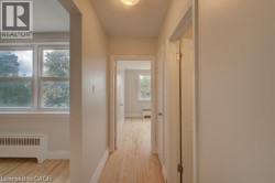 Light wood-finish flooring throughout, white trim, and a flush mount ceiling light - 