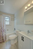 White vanity with black cabinet pulls, integrated sink, chrome faucet, and overhead light bar - 