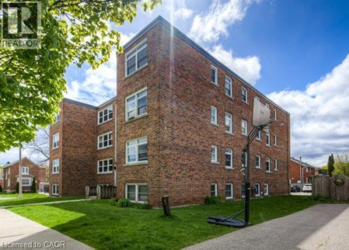Brick exterior building with multiple windows and a manicured lawn - 141 Chapel Street, Kitchener, ON 