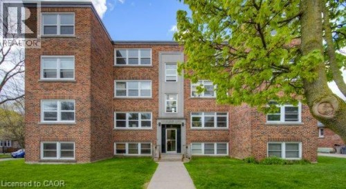 Brick exterior facade with multiple windows and a central entrance - 141 Chapel Street, Kitchener, ON 