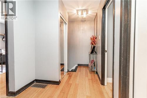 Hardwood-style flooring throughout, flush-mount ceiling fixture, and a mirrored closet door - 52 Charters Road, Brampton, ON 