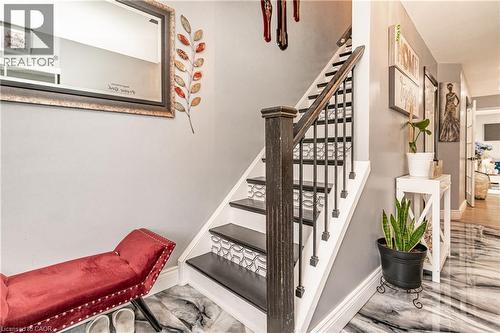 Two-tone staircase with black treads and patterned risers, dark wood newel post and railings, and metal balusters - 52 Charters Road, Brampton, ON 