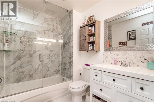 White vanity with dark hardware, white countertop, and mosaic tile backsplash - 52 Charters Road, Brampton, ON 