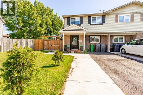 Cream-colored siding exterior with dark shutters, brick facade, covered entry, and a paved driveway - 52 Charters Road, Brampton, ON 