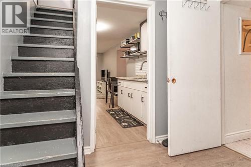 Wood-finish flooring, white cabinetry, subway tile backsplash, and light-toned countertops - 52 Charters Road, Brampton, ON 