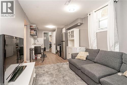 Open-concept living area with wood-finish flooring, a kitchen featuring a white subway tile backsplash, and stainless steel appliances - 52 Charters Road, Brampton, ON 