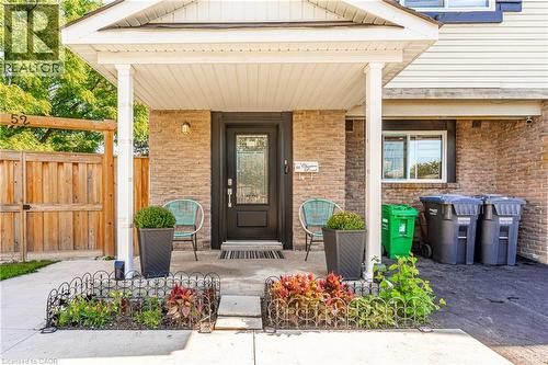 Front entry featuring brick exterior, wood fence, covered porch, and front door with decorative glass inlay - 52 Charters Road, Brampton, ON 