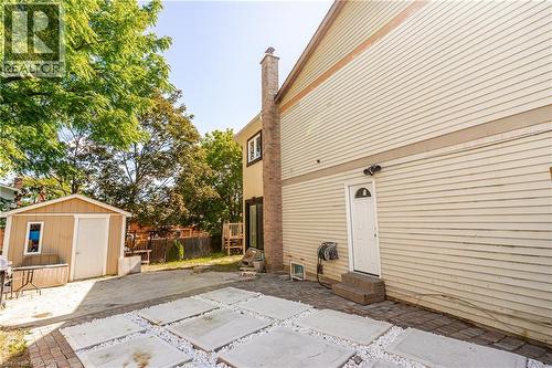 Paved patio area with large square pavers, white gravel accents, and a separate storage shed - 52 Charters Road, Brampton, ON 
