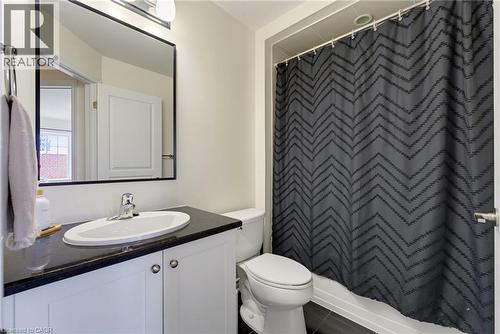 White vanity with dark countertop, undermount sink, and chrome faucet - 541 Winston Road Unit# 50, Grimsby, ON 
