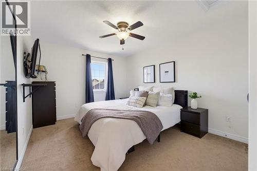 Neutral wall colors, carpeted flooring, a ceiling fan with integrated lighting, and a window with roller blinds - 541 Winston Road Unit# 50, Grimsby, ON 