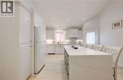 Kitchen featuring white cabinetry, light wood-finish flooring, a central island with a light-toned countertop, and recessed lighting - 245 Fern Crescent, Waterloo, ON 