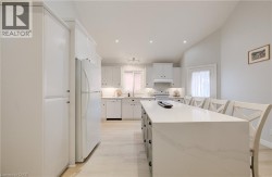 Kitchen featuring white cabinetry, light wood-finish flooring, a central island with a light-toned countertop, and recessed lighting - 