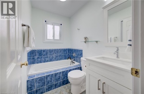 White vanity with integrated sink, chrome faucet, and framed mirror - 245 Fern Crescent, Waterloo, ON 