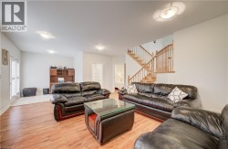 Wood-finish flooring throughout, integrated ceiling lighting, built-in shelving, and a wood staircase with balusters - 