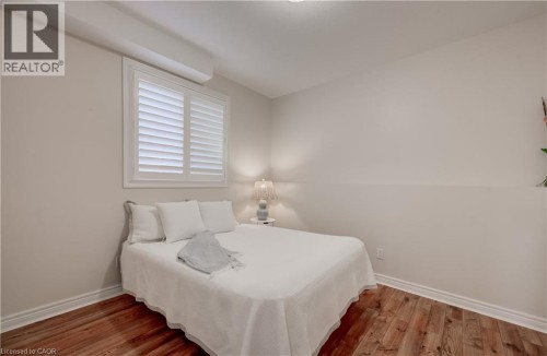 Wood-finish flooring with white baseboards, white window shutters, and neutral wall paint - 245 Fern Crescent, Waterloo, ON 