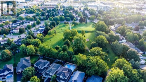 Aerial depiction of a residential area featuring detached homes, tree-lined streets, and a central green space - 245 Fern Crescent, Waterloo, ON 
