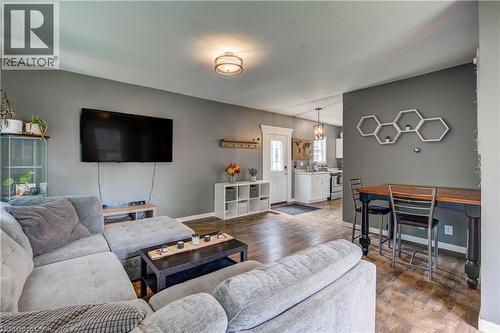 Open-concept living area with wood-finish flooring, recessed lighting, and a modern ceiling fixture - 146 Benson Street, Ingersoll, ON 