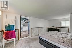 White painted walls with brick-finish wainscoting, light carpet flooring, and a window with blinds - 