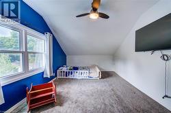 Vaulted ceiling with a ceiling fan, carpeted flooring, and a window with white trim - 