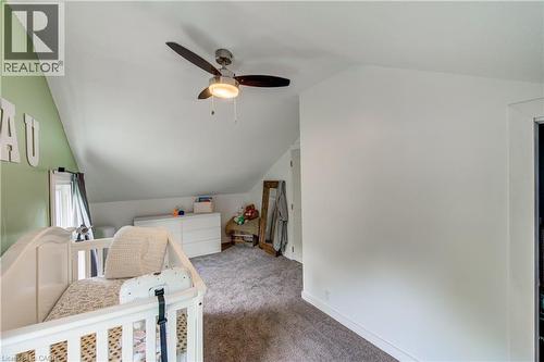 Sloped ceilings with a ceiling fan light fixture, carpeted flooring, and a window with white trim - 146 Benson Street, Ingersoll, ON 