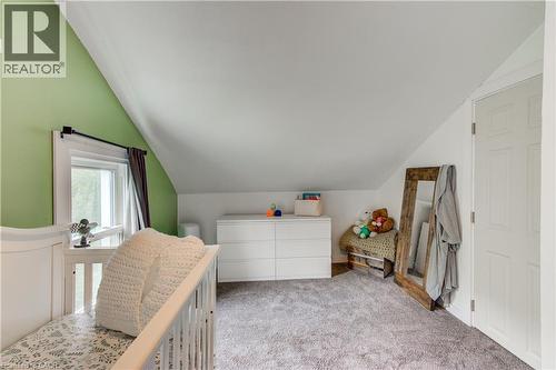 Bedroom with sloped ceilings, a window with trim, soft gray carpeting, and a paneled door - 146 Benson Street, Ingersoll, ON 