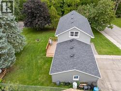 One and a half-story residence with gray siding, dark shingle roofs, and white trim - 