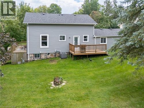 Expansive lawn with a built-in fire pit, multiple wood decks, and a gray siding exterior - 146 Benson Street, Ingersoll, ON 