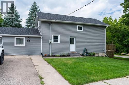Gray siding exterior with dark shingle roofing, featuring a concrete walkway and a green lawn - 146 Benson Street, Ingersoll, ON 