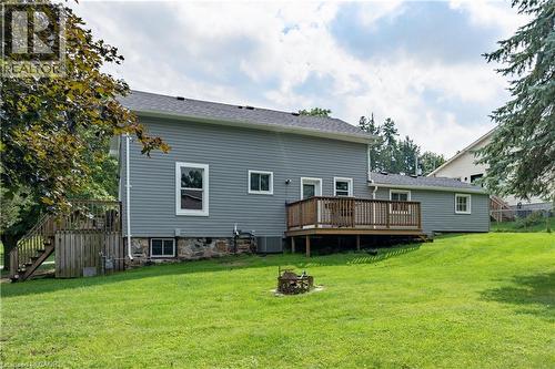 Expansive yard with green lawn, large deck, and stone foundation detailing - 146 Benson Street, Ingersoll, ON 