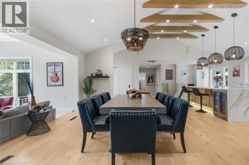 Vaulted ceiling with exposed wood beams, wood-finish flooring, built-in wine refrigerators, pendant lighting, and recessed lighting - 293 North Shore Boulevard E, Burlington, ON 