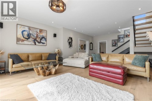 Light wood-finish flooring, recessed lighting, modern open-riser staircase, and a contemporary ceiling fixture - 293 North Shore Boulevard E, Burlington, ON 