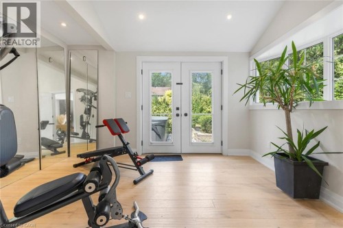 Hardwood-style flooring, mirrored wall, recessed lighting, white French doors, and transom windows - 293 North Shore Boulevard E, Burlington, ON 