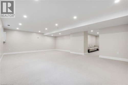 Expansive room with neutral carpeting, recessed lighting, and light-toned wall finishes - 293 North Shore Boulevard E, Burlington, ON 
