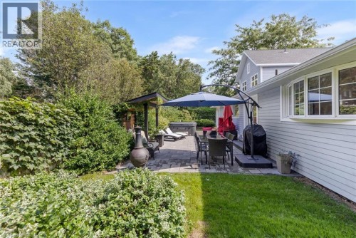Expansive backyard featuring a paver patio, a shaded pergola, a spa, and a bay window - 293 North Shore Boulevard E, Burlington, ON 