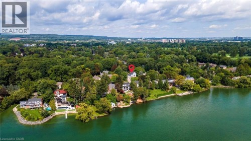 Waterfront property with extensive tree coverage and urban amenities visible in the distance - 293 North Shore Boulevard E, Burlington, ON 