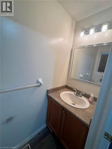 Vanity with wood-finish cabinetry, integrated sink, and laminate countertop - 717 Activa Avenue, Kitchener, ON 