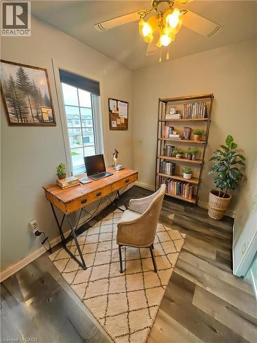 Wood-finish flooring, a ceiling fan with integrated lighting, and a large window with roller shades - 717 Activa Avenue, Kitchener, ON 