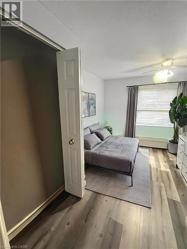 Wood-finish flooring, ceiling fan with integrated lighting, window with blinds and drapes, and a baseboard heater - 717 Activa Avenue, Kitchener, ON 