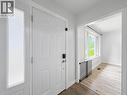 Entry door with frosted glass sidelight, light wood-finish flooring, and bright white walls - 220 Cairn Street, London, ON 
