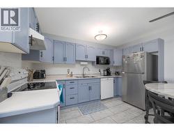 A closer look at the kitchen cabinetry, full appliance package and useful preparation space. - 